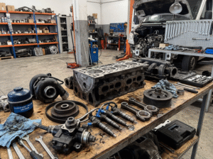 Mecânico verificando a compatibilidade de peça em van diesel durante manutenção automotiva